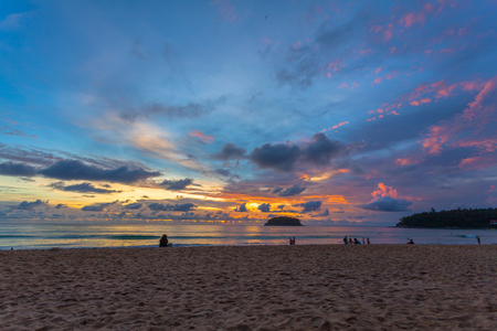 beautiful sunset behind Pu island at Kata beach Phuket. a lot of tourists relax on the beach during sunset.の写真素材