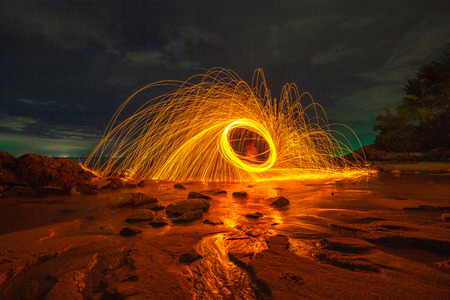 cool burning steel wool art fire work photo experiments on the beach at sunset