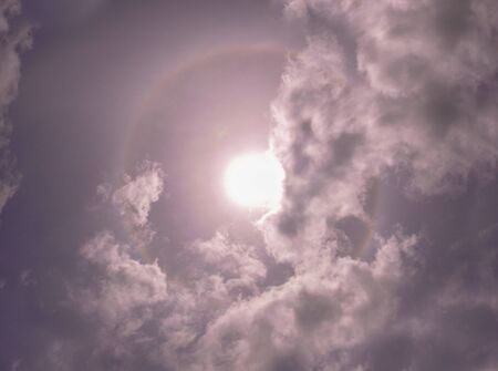Sun halo in cloudy sky at middayの写真素材