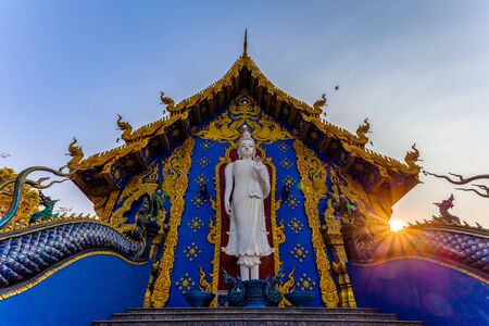 white standing buddha on the back of church in Rong Suea Ten temple Chiang Rai Thailand.の写真素材