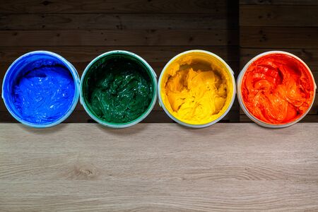 blue green yellow and orange colors of Plastisol ink in white barrel are dripping. Plastisol ink useful for print tee shirtの写真素材