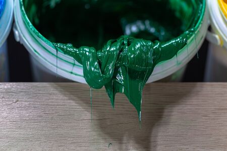 green color of Plastisol ink in white barrel are dripping. Plastisol ink useful for print tee shirtの写真素材