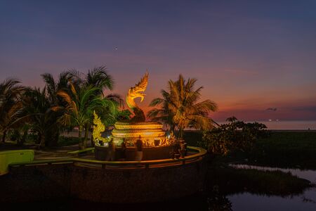 sunset behind golden dragon statue on Karon beach Phuket Thailandの写真素材