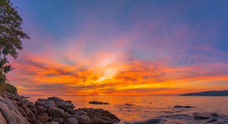 stunning red sky at sunset over the sea at Karon beach Phuket Thailandの写真素材