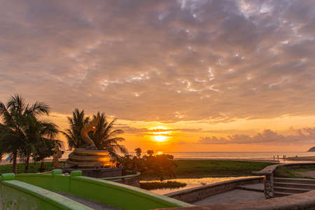 sunset behind golden dragon statue on Karon beach Phuket Thailand