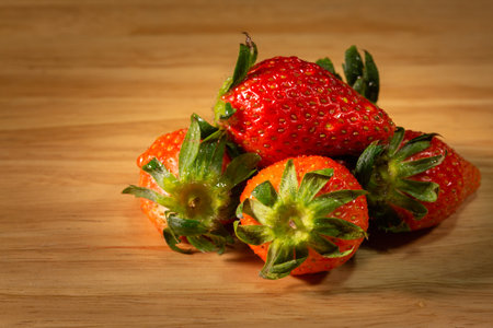 the sweet soft red fruit with a seed-studded surface on the wood.の写真素材