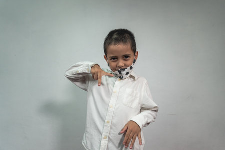 Cute caucasian young kid with face mask. Protection versus viruses and infection. 
Studio portrait, concept with white backgroundの写真素材