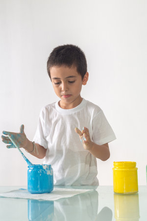 A boy was joyfully mixing a new color.
Boy mixing colors Learning materials in school, Montessori method that children manage.
high footage in studio shot. colorful background.の写真素材