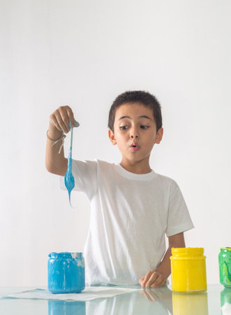 A boy was joyfully mixing a new color.Boy mixing colors Learning materials in school, Montessori method that children manage.high footage in studio shot. colorful background.の写真素材