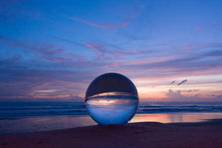 The natural view of the sea and sky in beautiful sunset are unconventional and beautiful inside crystal ball. A image for a unique and creative travel.の写真素材
