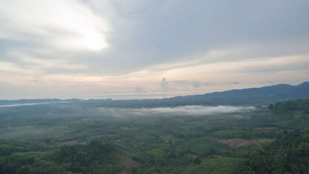aerial view scenery sunrise mist above the mountain in tropical rainforest.slow floating fog...