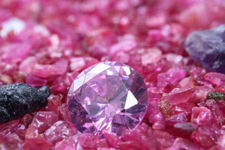amethyst diamonds on placed on a pile of raw ruby rough gemstone.
colorful raw stone background.lived a life of luxury.の写真素材