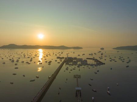aerial view beautiful sunrise cloud above Chalong pier.Sunrise with sweet yellow color light rays and other atmospheric effects.colorful reflection of sunrise in the sea background.の写真素材