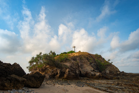 The island where the lighthouse is located There is an unusual rock formation with colorful round stones of various sizes filling the beach below. Lanta lighthouse is popular landmark of Krabi.の写真素材