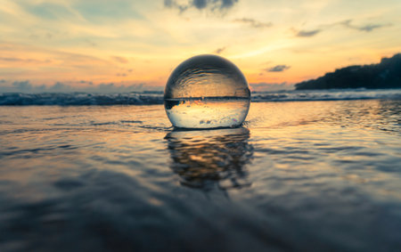 Magnificent sky above the crystal ball on the beach.The beautiful reflection of the sky above the crystal ball on the wet sand beach.Unique and creative travel and nature ideaの写真素材