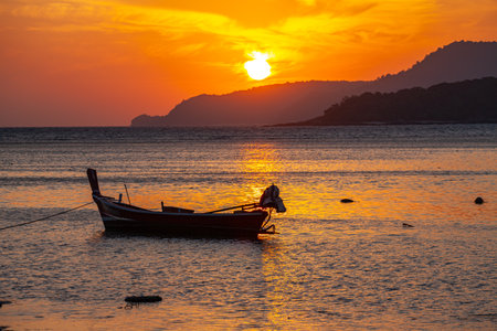amazing yellow sky of sunrise above the island.
scenic reflection of beautiful sunshine in the sea fishing boats are floating in the Rawai sea.の写真素材