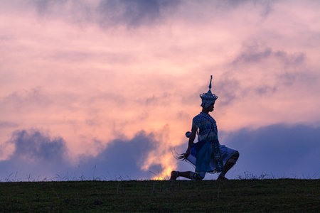 Nora performs dance moves in the field at sunset.beautiful sky background.The sun casts a...