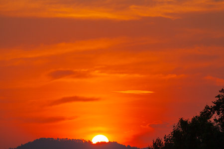 exotic The big sun in red sky at sunset. Gradient color.
Sunset with bright red light rays.
amazing red sky.phone antenna post.の写真素材