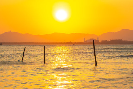 scenery reflection of the sun in golden sky at sunset. 
bright yellow sky in the beautiful evening.
Scene of Colorful romantic sky sunset with gold color of the sky background.の写真素材
