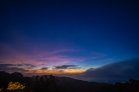 stunning mountainous landscape at sunrise with vibrant orange and pink hues illuminating the clouds...