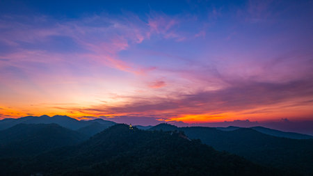 Aerial view of amazing sky in twilight above Phra Yai Wat Phra That Doi Phra Chan (Daibutsu) on the mountain in Lampang Thailand. stunning sunset casting vibrant hues over mountainous landscape.の写真素材