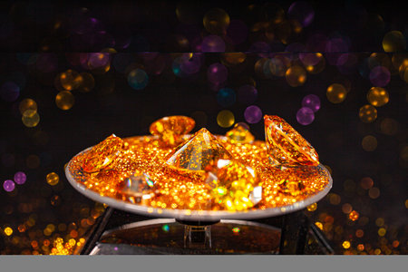 Yellow sapphire diamonds are arranged on a golden yellow velvet cloth. The sapphire sparkles beautifully. The diamonds are valuable and luxurious.の写真素材