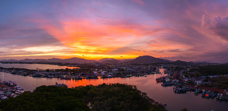 Aerial view of a panoramic view of colorful sky over a large fishing port. This port is important as...