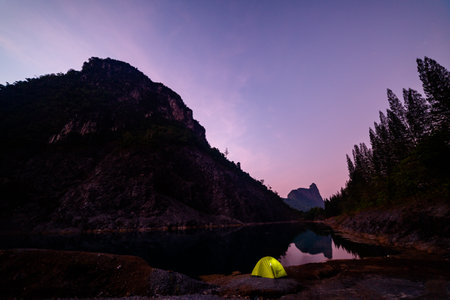 A yellow tent for camping beside the large pond There is blue water and the pine forest has a beautiful view like Switzerland.
beautiful The reflection of the blue sky in the emerald green pond.の写真素材