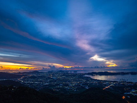 aerial view Horizon panorama mountain and dramatic twilight sky and cloud sunrise background.
Twinkling lights along the beach and in various towns around Phuket Island. 
lighting background.の写真素材