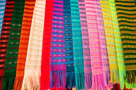 A vibrant display of traditional handwoven fabrics featuring an array of bold and rich colors with intricate patterns. the craftsmanship and cultural heritage of weaving traditions in the northの写真素材