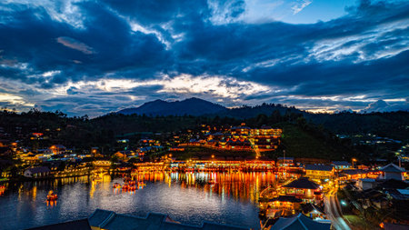 Baan Rak Thai Village at sunset reflections of houses and restaurants along the lake in Chinese-style architecture with colorful lights line the water. a popular tourist attraction in Mae Hong Sonの写真素材