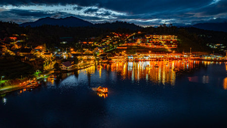 Baan Rak Thai Village at sunset reflections of houses and restaurants along the lake in Chinese-style architecture with colorful lights line the water. a popular tourist attraction in Mae Hong Sonの写真素材