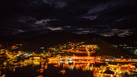 At dusk the reflections of the lights from the village the lake in Chinese-style structures with...