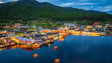 Baan Rak Thai Village at sunset reflections of houses and restaurants along the lake in Chinese-style architecture with colorful lights line the water. a popular tourist attraction in Mae Hong Sonの写真素材