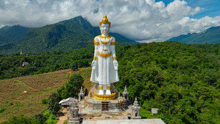 Big Buddha Brahma Panyo standing tall in front of Doi Luang mountain, Chiang Mai symbolizing peace and spirituality in a natural setting.Captured in an elevated rural area. High mountain backgroundの写真素材