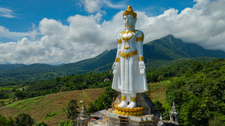 Big Buddha Brahma Panyo standing tall in front of Doi Luang mountain, Chiang Mai symbolizing peace and spirituality in a natural setting.Captured in an elevated rural area. High mountain backgroundの写真素材