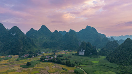 amazing aerial view of colorful sky at sunrise over mountains. The serene landscape, dotted with valleys and rivers, creates a mesmerizing contrast against the glowing clouds. wonderful landscapeの写真素材
