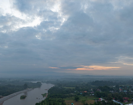 Aerial view of scenery sunrise over A river flows through a misty mountain pass with rural villages with scattered villages and lush greenery stretching into the horizon. village at Hod Chiang Maiの写真素材