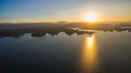 stunning aerial scene captures the meeting point of rugged mountains and endless lake. With vibrant...