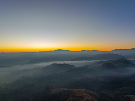 Aerial View of An image of sky in sunrise above a valley of mist. High peaks wonderful morning sunrise nature Landscape. Beautiful sunset tropical landscape background.の写真素材