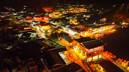 At dusk the reflections of the lights from the village the lake in Chinese-style structures with colorful lights lined the waterfront. Ban Rak Thai is a popular tourist attraction in Mae Hong Sonの写真素材