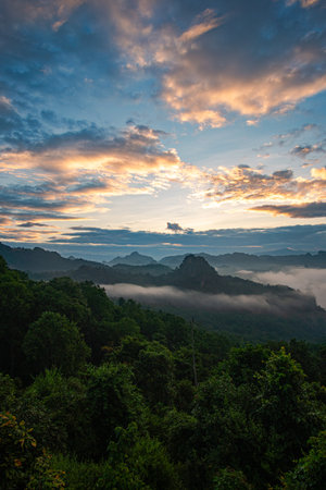 Aerial view of the sun above The sun over the mountain peaks shines through the valley. Cloudy skies...