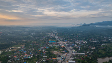 Aerial view of scenery sunrise over A river flows through a mountain pass with rural villages and lush greenery stretching into the horizon. village at Hod Chiang Maiの写真素材
