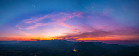 Aerial view of amazing sky in twilight above Phra Yai Wat Phra That Doi Phra Chan (Daibutsu) on the mountain in Lampang Thailand. stunning sunset casting vibrant hues over mountainous landscape.の写真素材