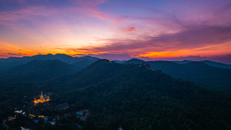 Aerial view of amazing sky in twilight above Phra Yai Wat Phra That Doi Phra Chan (Daibutsu) on the mountain in Lampang Thailand. stunning sunset casting vibrant hues over mountainous landscape.の写真素材