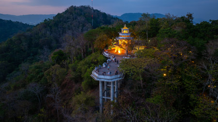 Aerial view of scenery Khao Rang viewpoint at twilight.view of a town nestled among lush green mountains at sunset, with a Pavilion structure perched on the hillside at Phuket town at Duskの写真素材