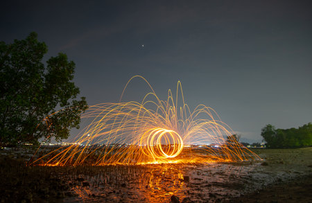 reflection of spark fire swirl from steel wool with long exposure speed motion abstract at twilight...