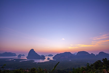 the flare light from the sun shines down on the islands. 
stunning aerial view of the beautiful Phang Nga Bay 
with Steep limestone hills protruding vertically from Thailand's emerald waters.の写真素材