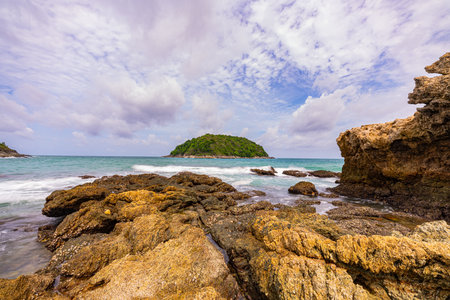 Around the island there are large rocks surrounding it. When a big wave hits, the water splashes and bursts into tall foam, looking beautiful and frightening. sandbars connect to the island.の写真素材