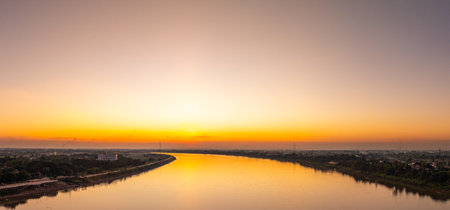 Stunning sunset over Kong river bridge. featuring dramatic clouds, golden hour light, and...